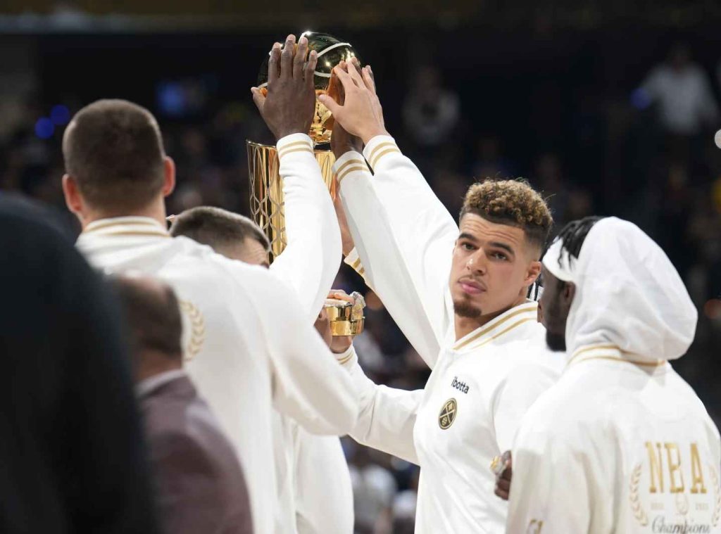The Denver Nuggets' Nikola Jokic, left, and forward Michael Porter Jr. touch the NBA championship trophy before an NBA basketball game against the Los Angeles Lakers on Tuesday, Oct. 24, 2023, in Denver. (Photo by David Zalubowski)